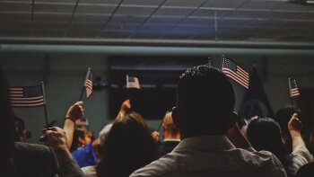 People in a room holding American flags.