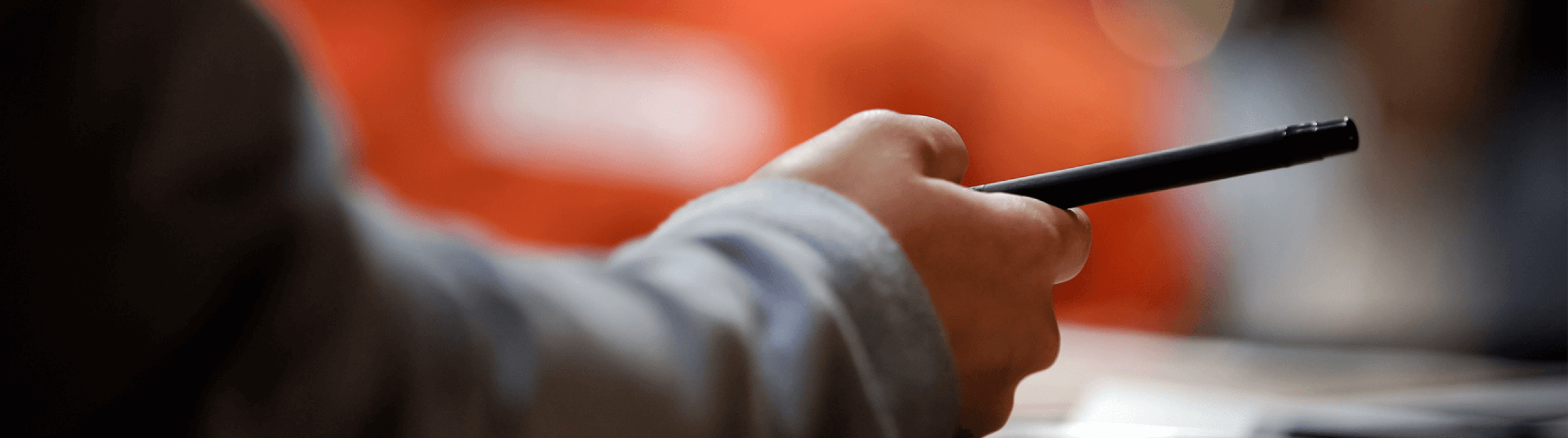 A hand holding a pen.