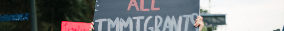 A protester holding a sign that reads "liberate all Immigrants".