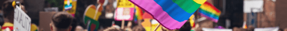 A rainbow flag above a pride parade.
