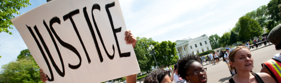 Protestors holding up sign with the word "Justice" on it.