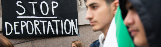 Photo of protestors with a sign saying "stop deportation".