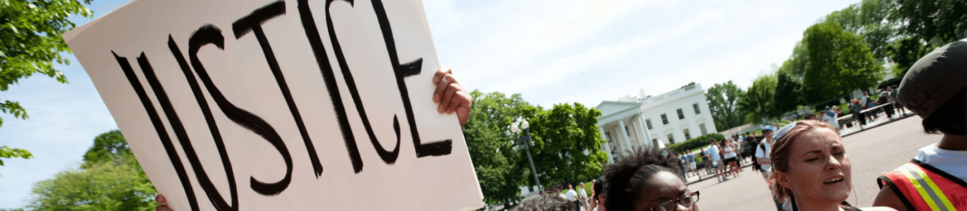 Protestors holding up sign with the word "Justice" on it.